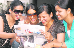 Teens reading newspaper